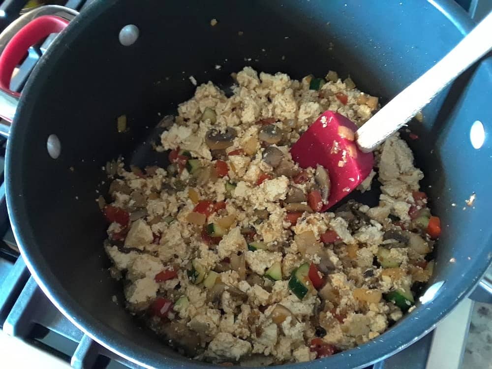 The scrambled tofu is spiced while cooking.