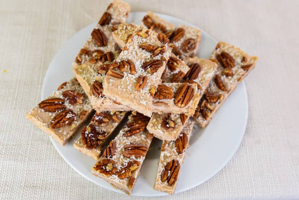 A stack of coconut pecan pie slices on a plate.