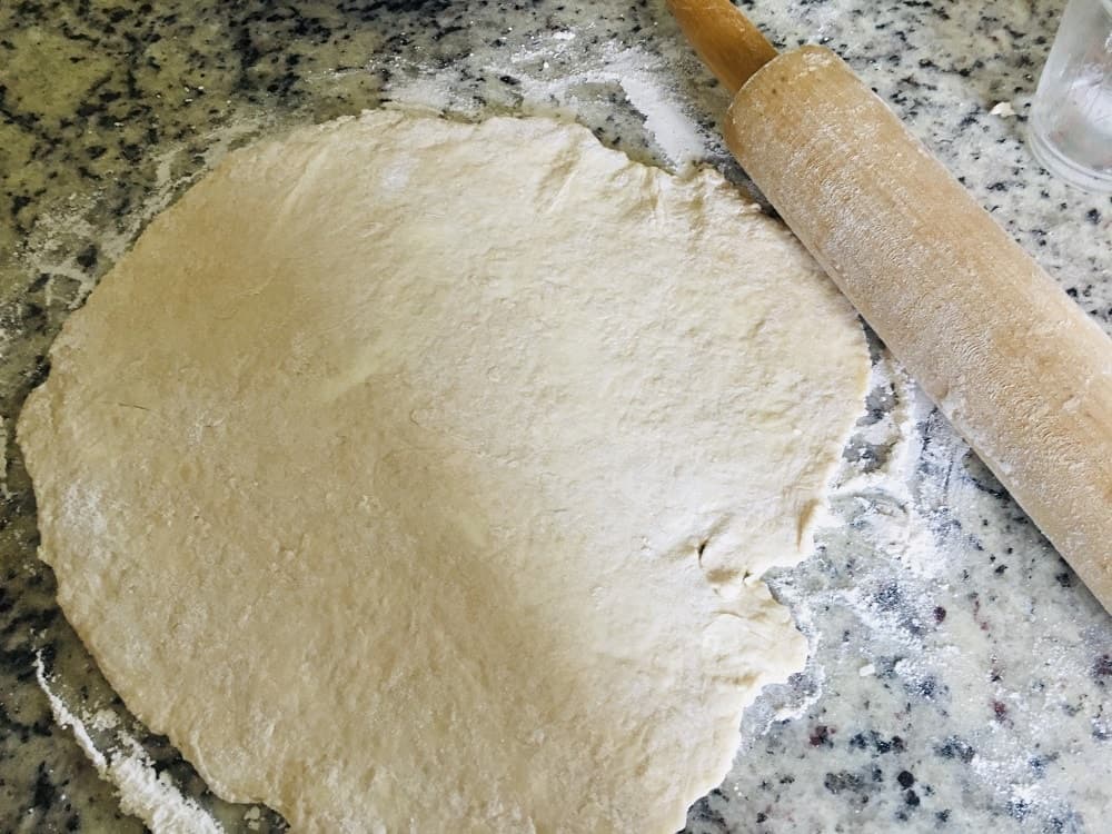 The dough is then flattened with the use of a rolling pin.