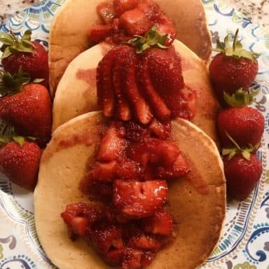 A plate of fresh fruit-topped pancakes.