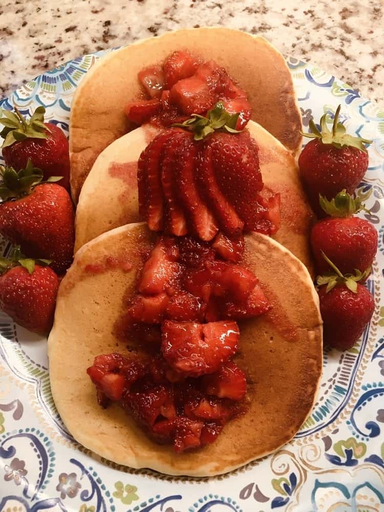 A plate of fresh fruit-topped pancakes.