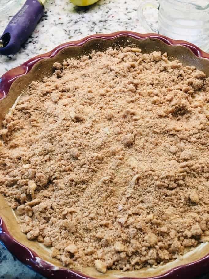 The crumble topping is distributed evenly onto the top.