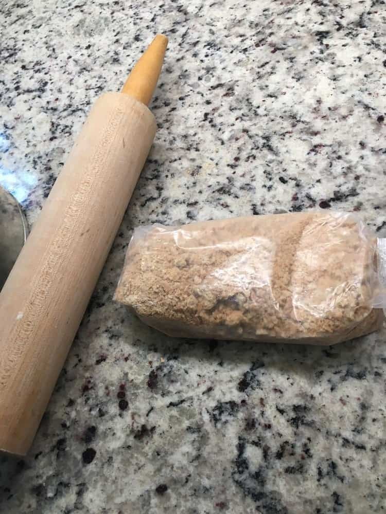 The graham crackers are crushed with the use of a rolling pin.