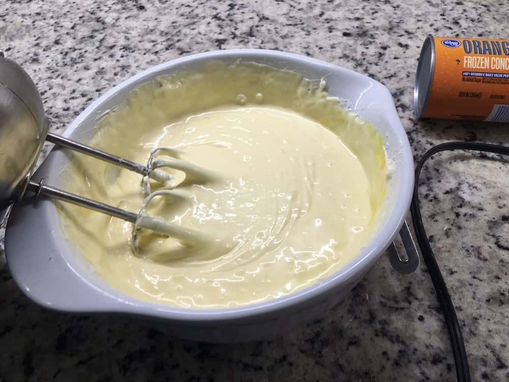 The cheesecake is mixed in a bowl with a machine mixer.