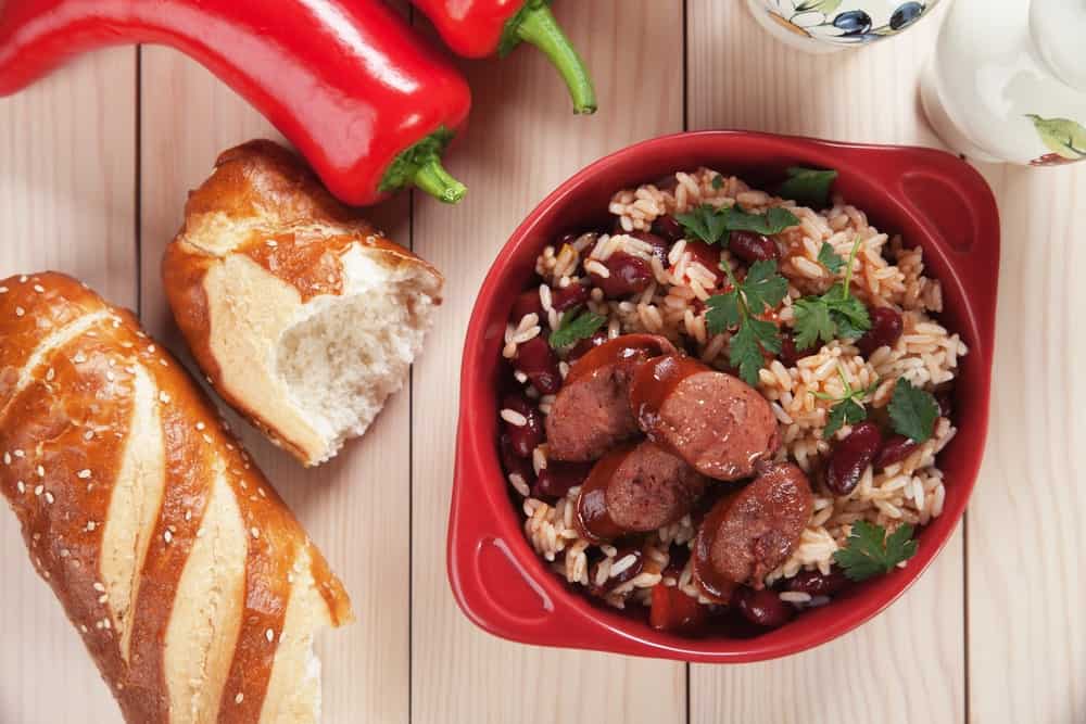 A bowl of freshly-cooked red beans and rice with sausage slices.