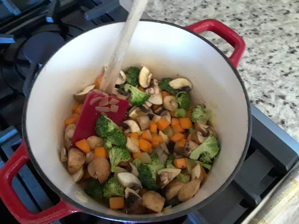The vegetables are sauteed in a pot.