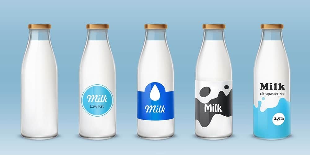 A row of different types of milk in glass bottles.