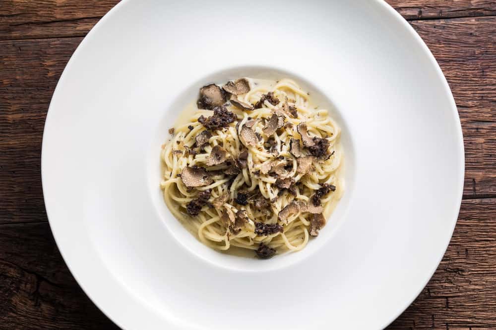 A plate of Truffle Cream Pasta on a wooden table.
