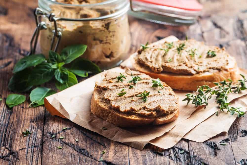 Chicken liver pate maison served on a couple of toasts with herbs.