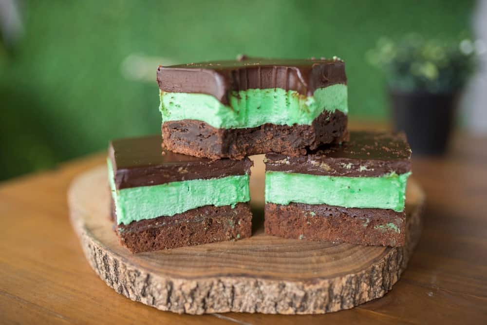 Pieces of chocolate mint brownies on a wooden board.