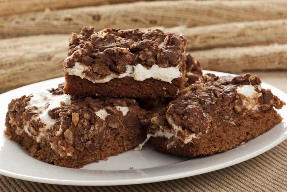 Pieces of marshmallow crunch brownie bars on a plate.