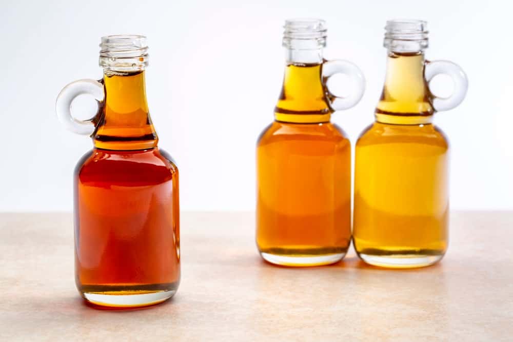 Three different types of maple syrups in small bottles.