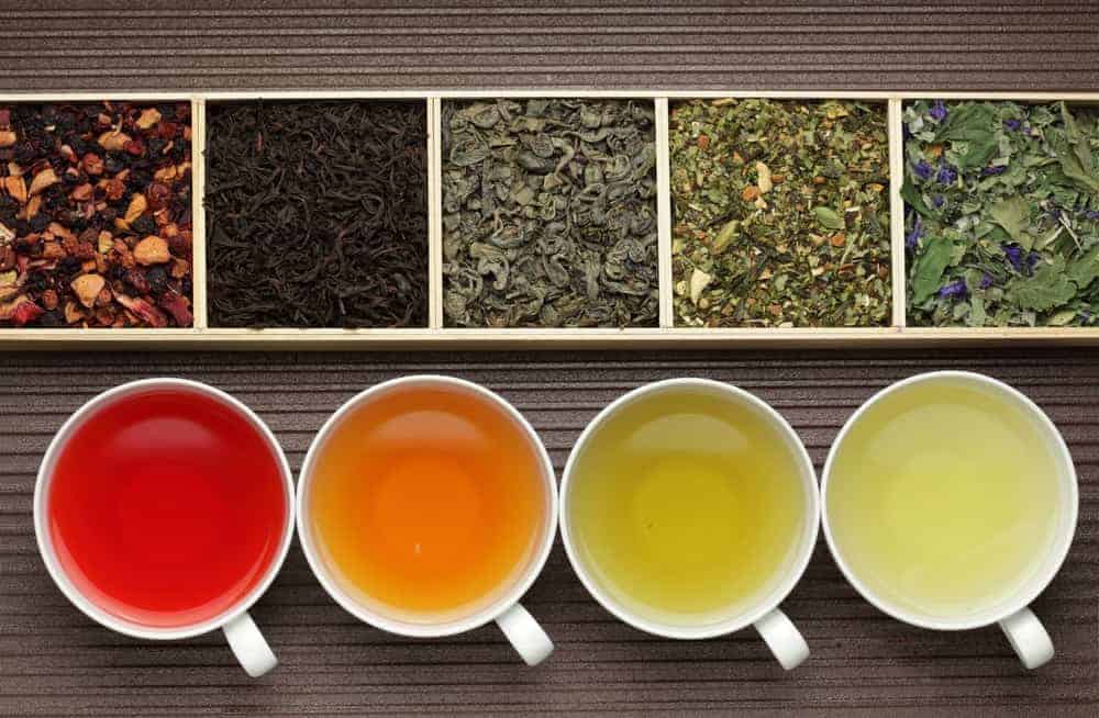Variety of tea on wooden box container and cups.