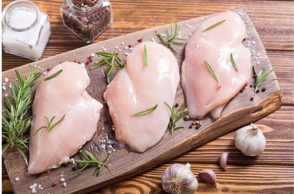 fresh chicken breasts on a cutting board