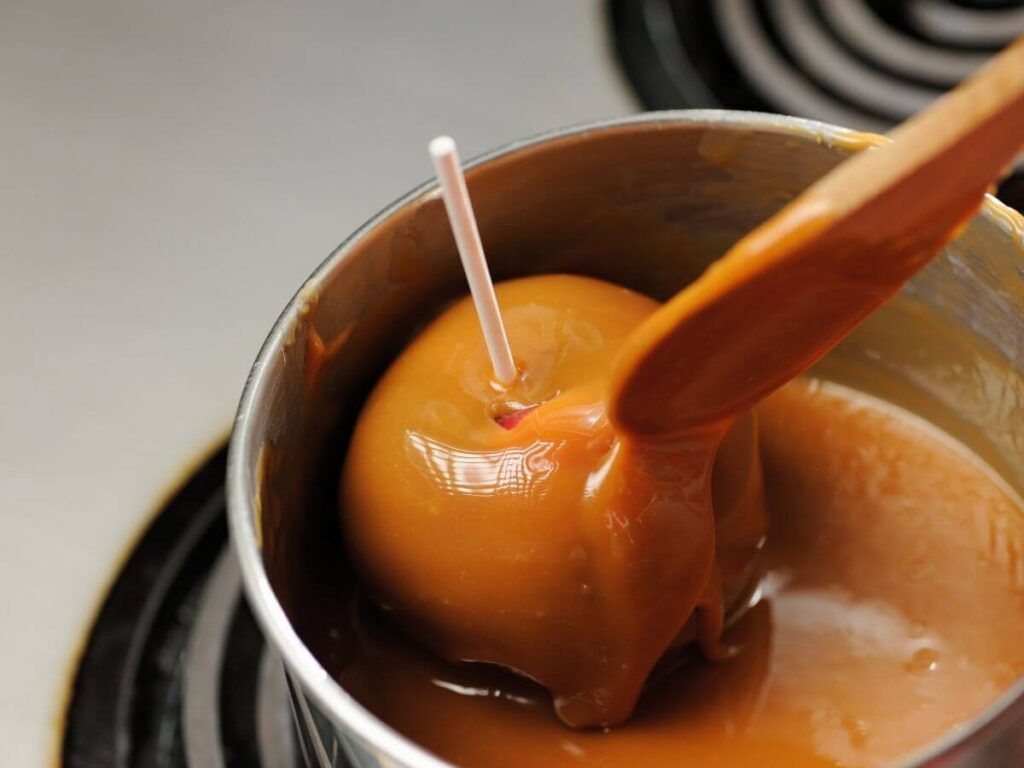 Apple being dipped in Caramel made from Condensed Milk 