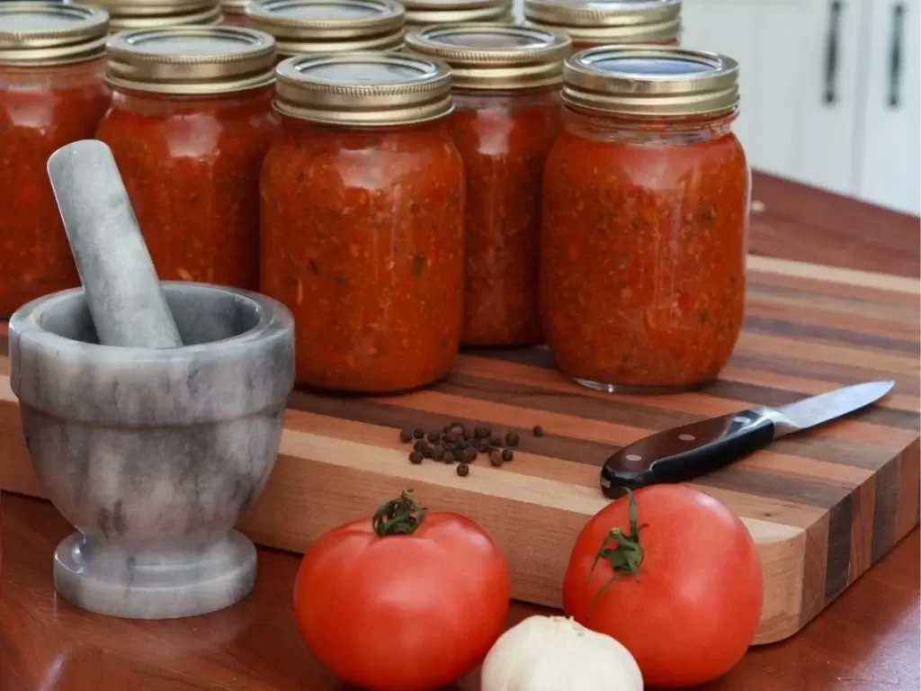 a bunch of mason jars filled with spaghetti sauce