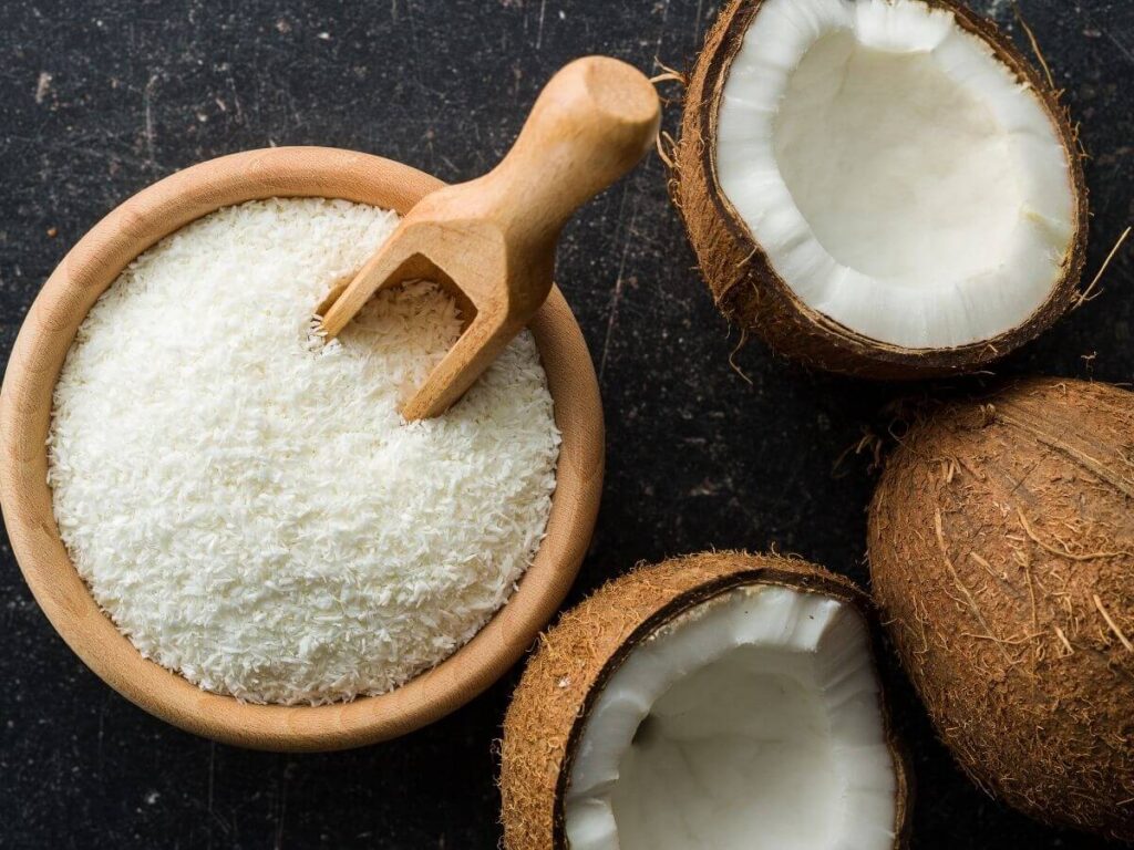 a bowl of coconut flakes and coconut halves