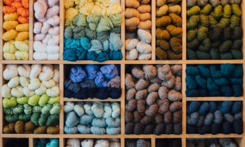 A shelf full of different colored yarn.